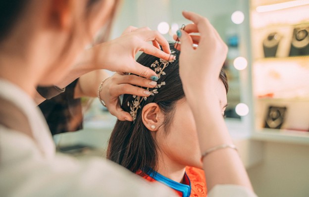 Girl getting a stylish headband around her head, presenting a fashionable accessory.